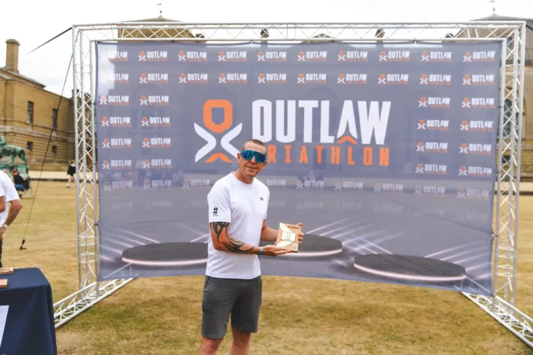 Hashtag Coaching head coach Nick on the Outlaw podium